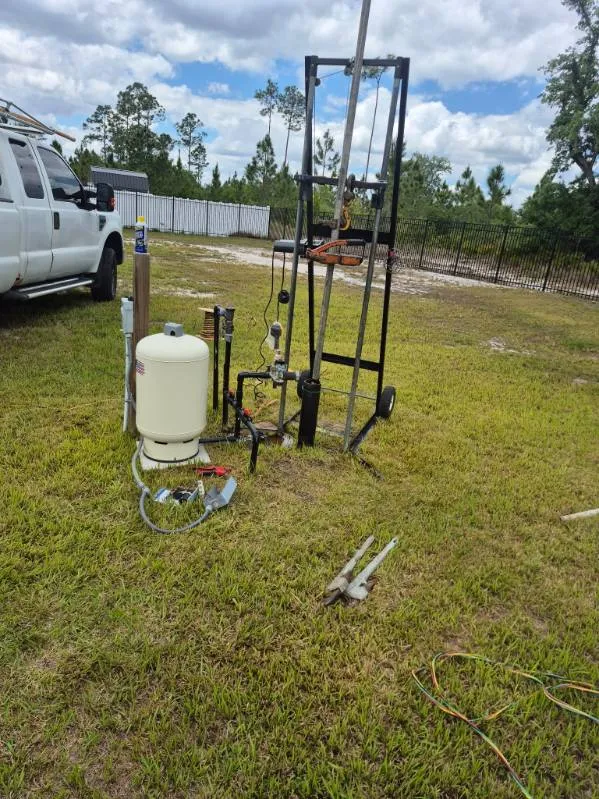 Watkins drill rig and service truck set up for a new well in a Central Florida yard