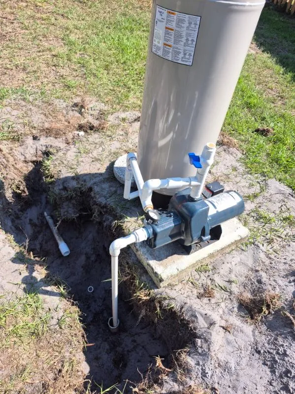 Freshly installed well pump and pressure tank at a job site